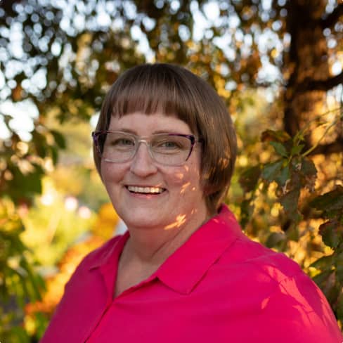 A woman with short hair and a red shirt smilling